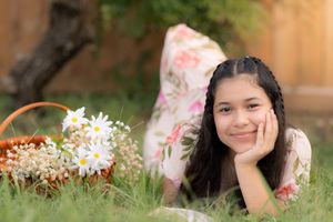 A collage of springtime outdoor portrait photos with children laying in grass and flowers under natural lighting. In Pearland, TX