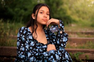 Model sitting with hand to cheek look at the sunset.