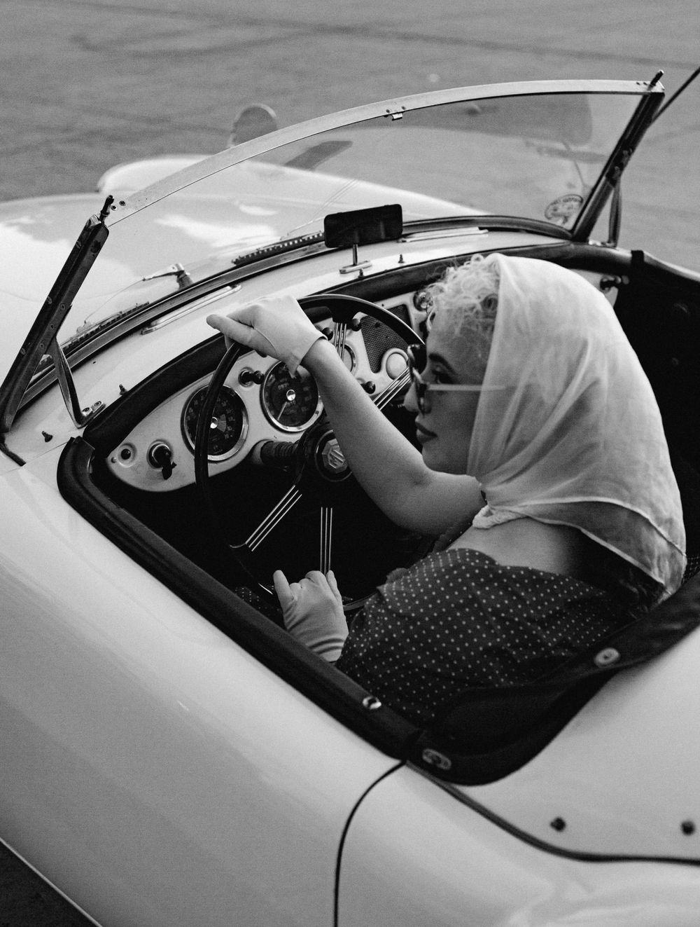 Interior view of a classic car showing details of the steering wheel and dashboard through windows.