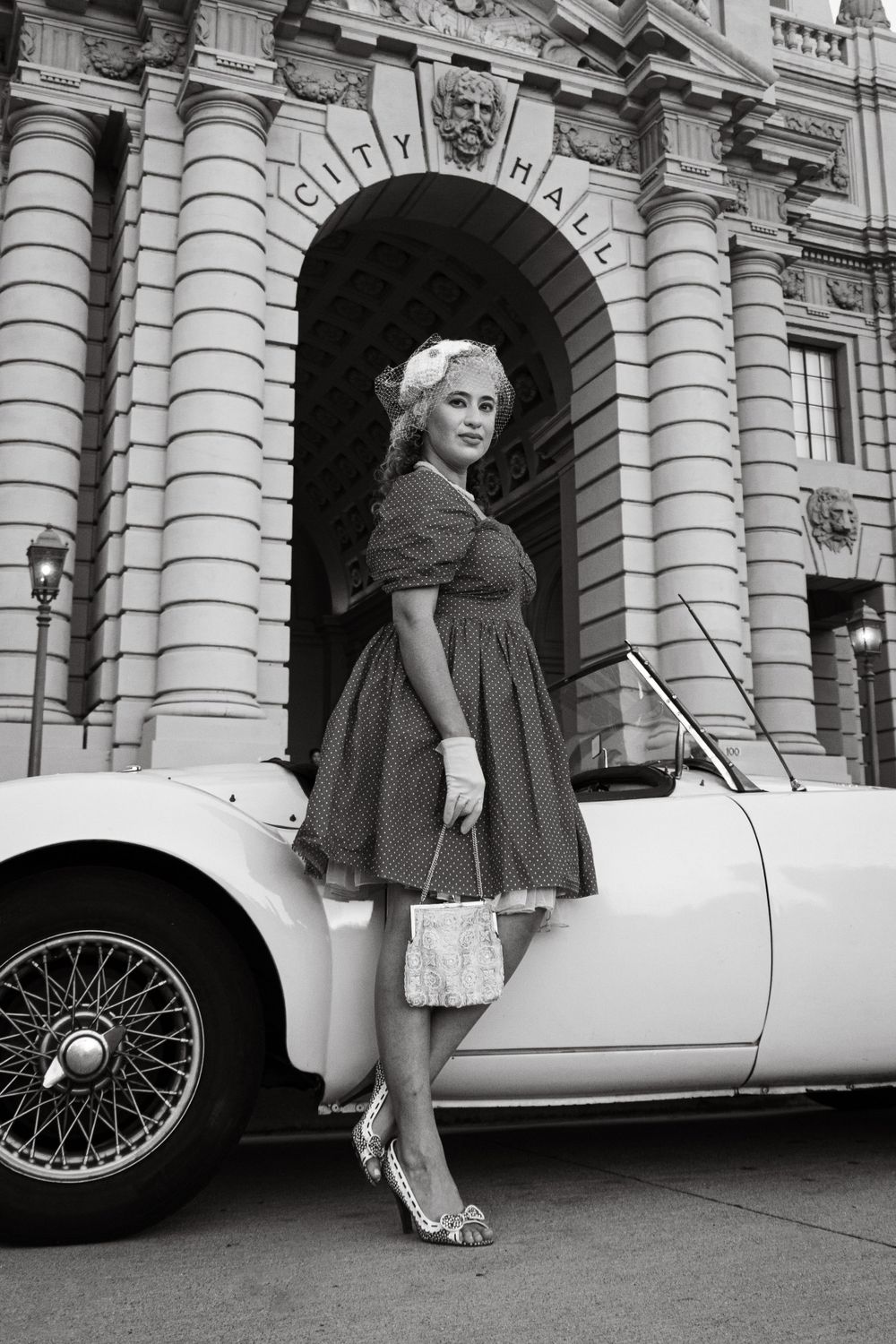 Black and white photos of a classic car parked by an elegant colonnade building.