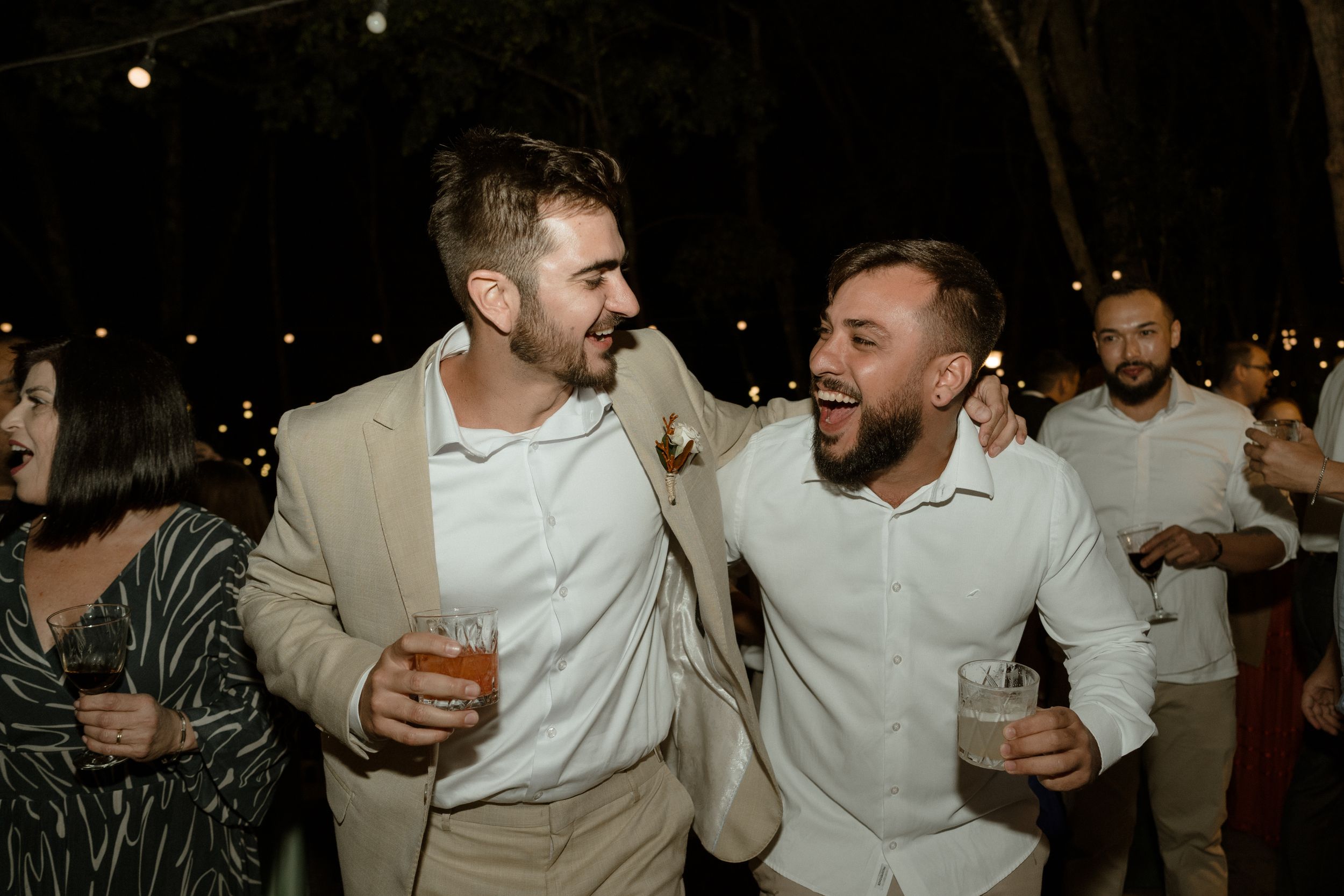 Group of friends celebrating at a nighttime outdoor event with drinks.