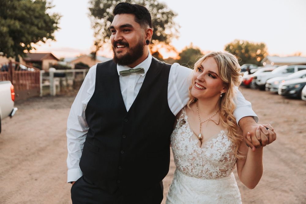 Joyful couple share a candid laugh together at their outdoor wedding.