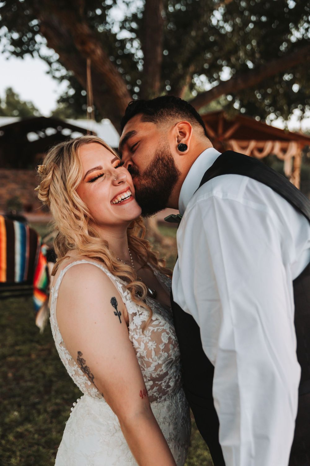 Intimate candid moment between newlyweds during sunset outdoor photoshoot.