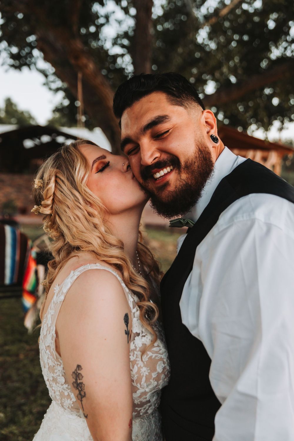 Sweet candid moment between newlyweds during their rustic outdoor wedding celebration.