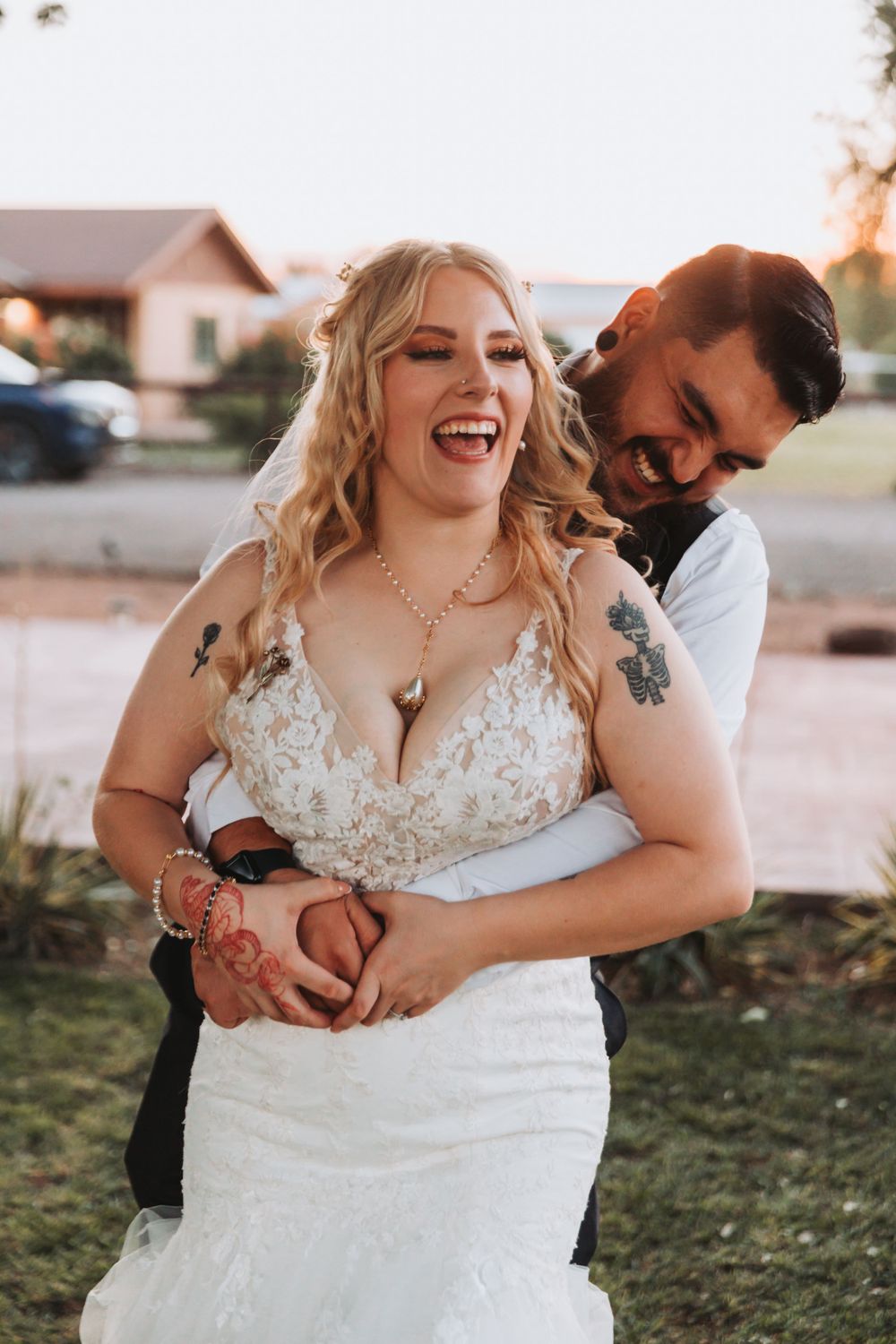 Candid laughter shared between newlyweds during outdoor wedding photoshoot.