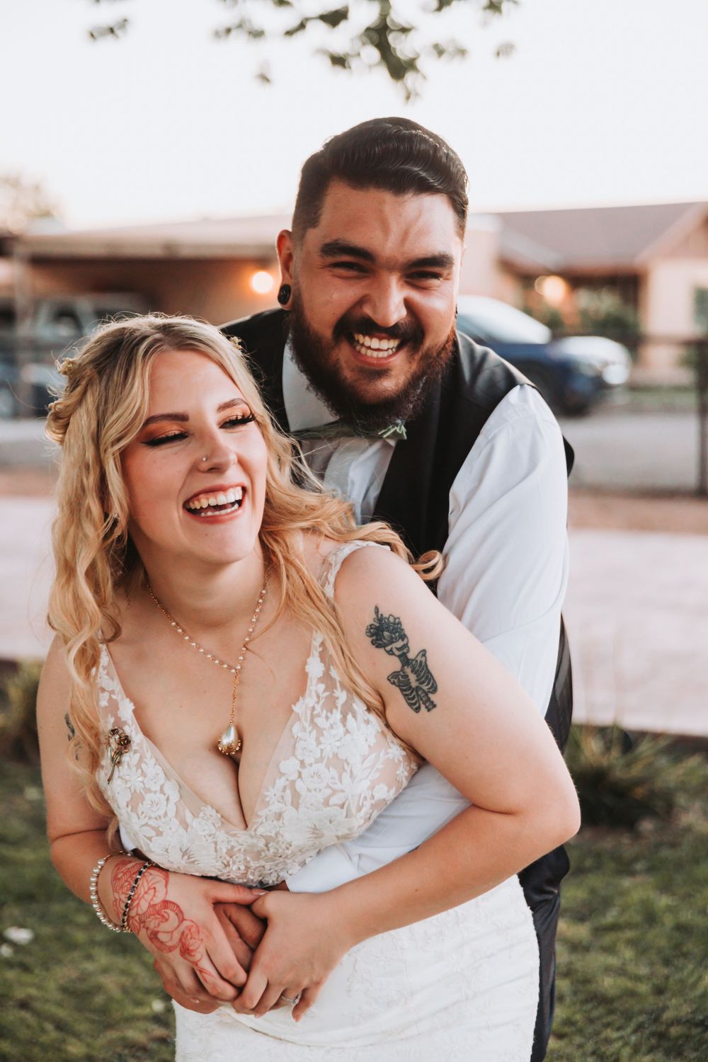 Joyful candid moment between couple during sunset wedding portraits.