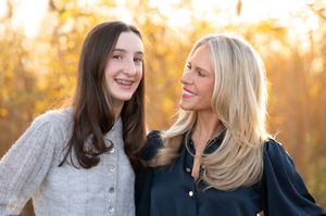 Family portrait session captured during golden hour in an autumn setting with warm lighting.
