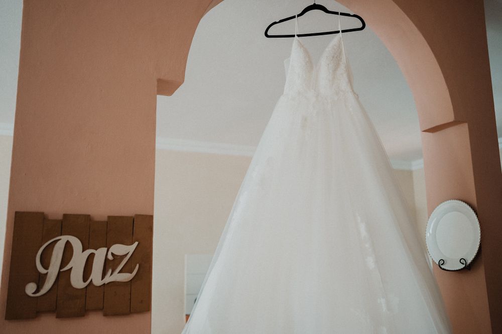 Wedding dress hanging peacefully, symbolizing the calm before the big day in Mazatlán
