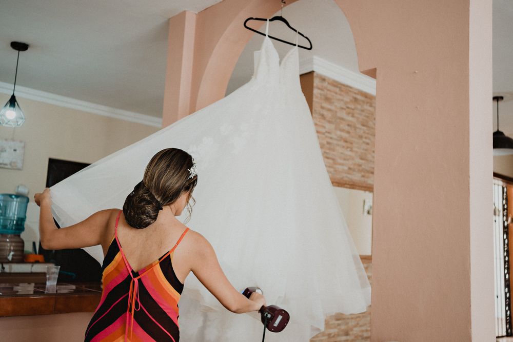 Bride ironing her wedding dress, preparing for her special day in a relaxed, personal moment