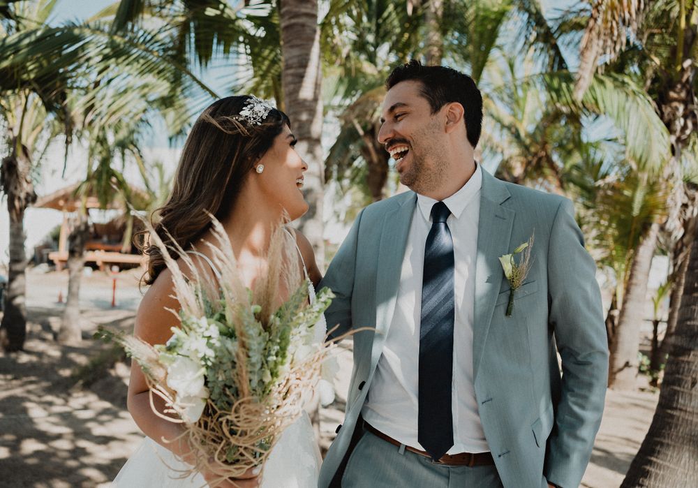 Couple walking and smiling, capturing their happiness and love on their wedding day in Mazatlán