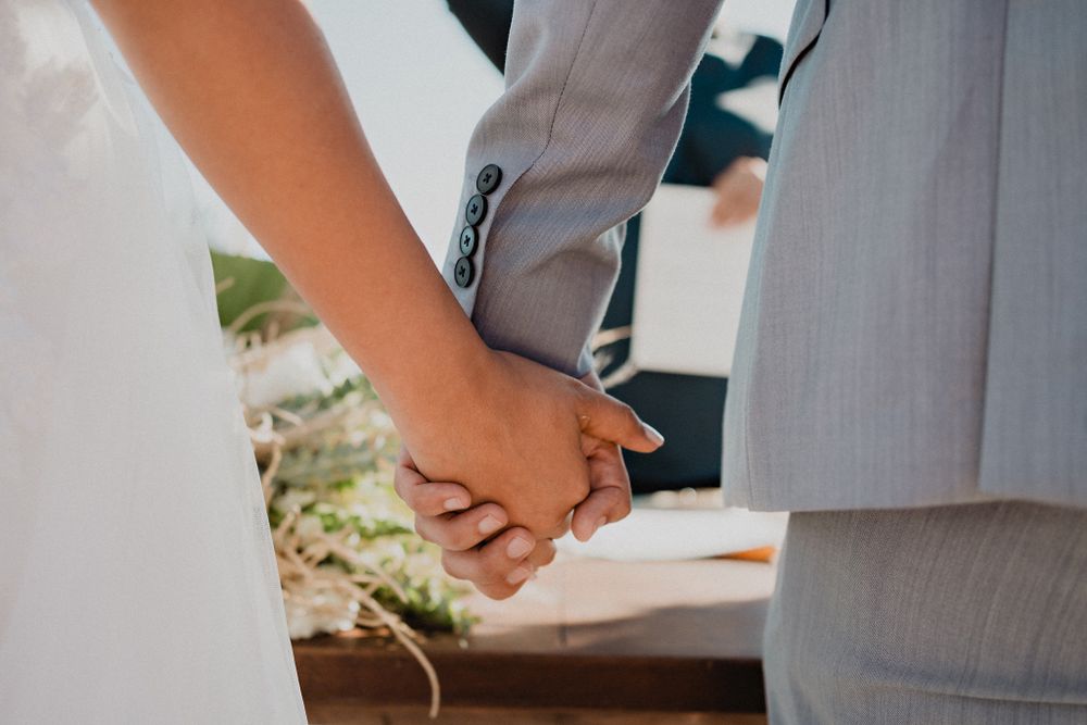 Couple holding hands, showcasing their connection and love on their special day in Mazatlán