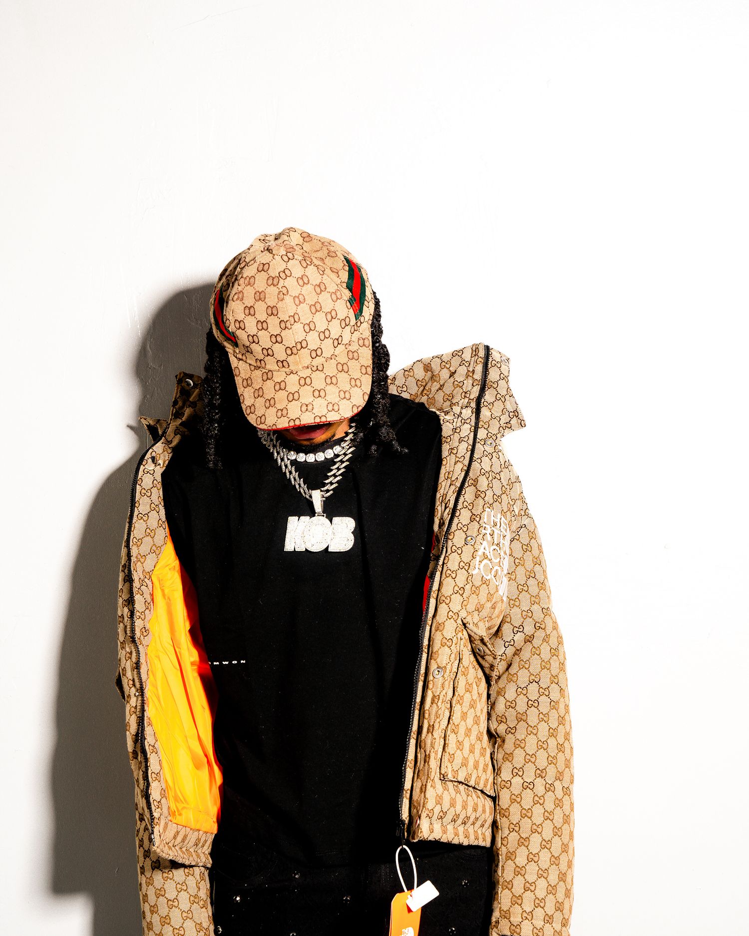 Designer outfit featuring a Gucci patterned jacket and black hoodie against white background.