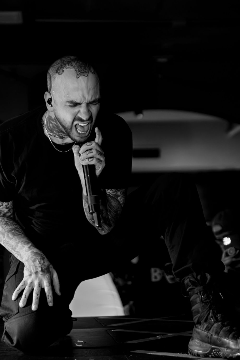 Black and white photo of performer singing intensely on stage.