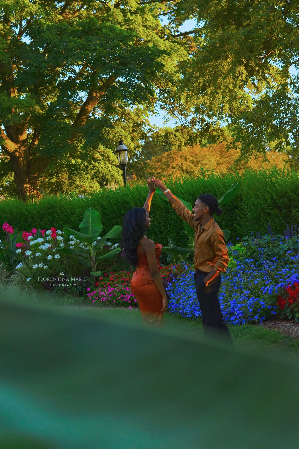 A playful moment captured in a garden setting with blooming flowers and golden sunlight.