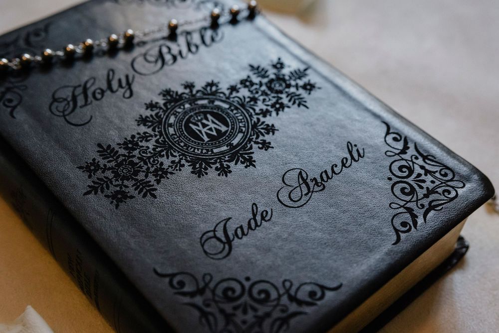 Vintage style Holy Bible with ornate black decorative cover design featuring floral patterns.