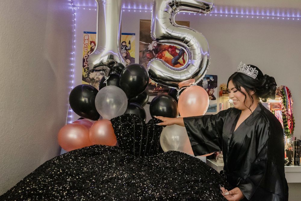 Party decorations featuring black and metallic balloons with the number 15.