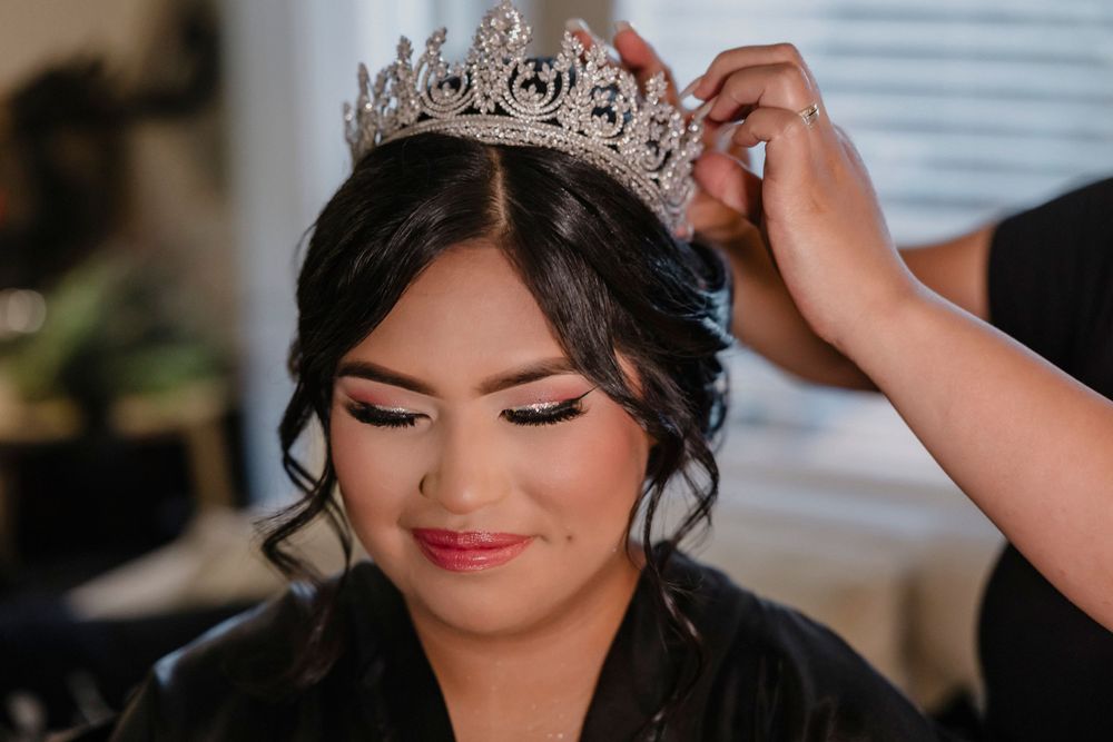 Beautiful bridal preparation scene with sparkly tiara being adjusted on elegant updo.