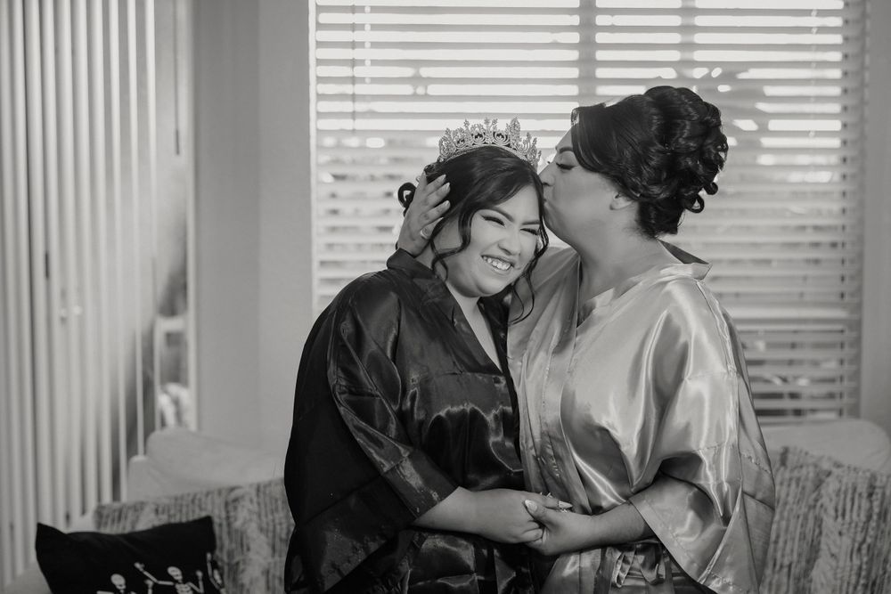 Intimate black and white moment shared during wedding preparation in natural window light.