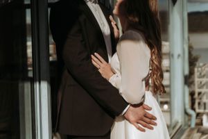 Romantic couple in formal attire embracing in an elegant setting.