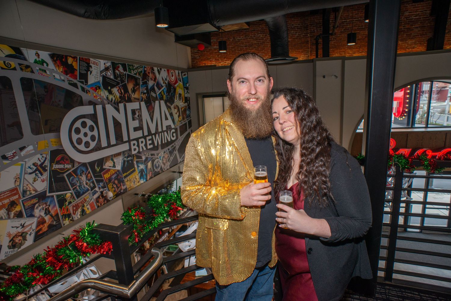 A couple shares an intimate moment in front of a cinema wall covered in posters.