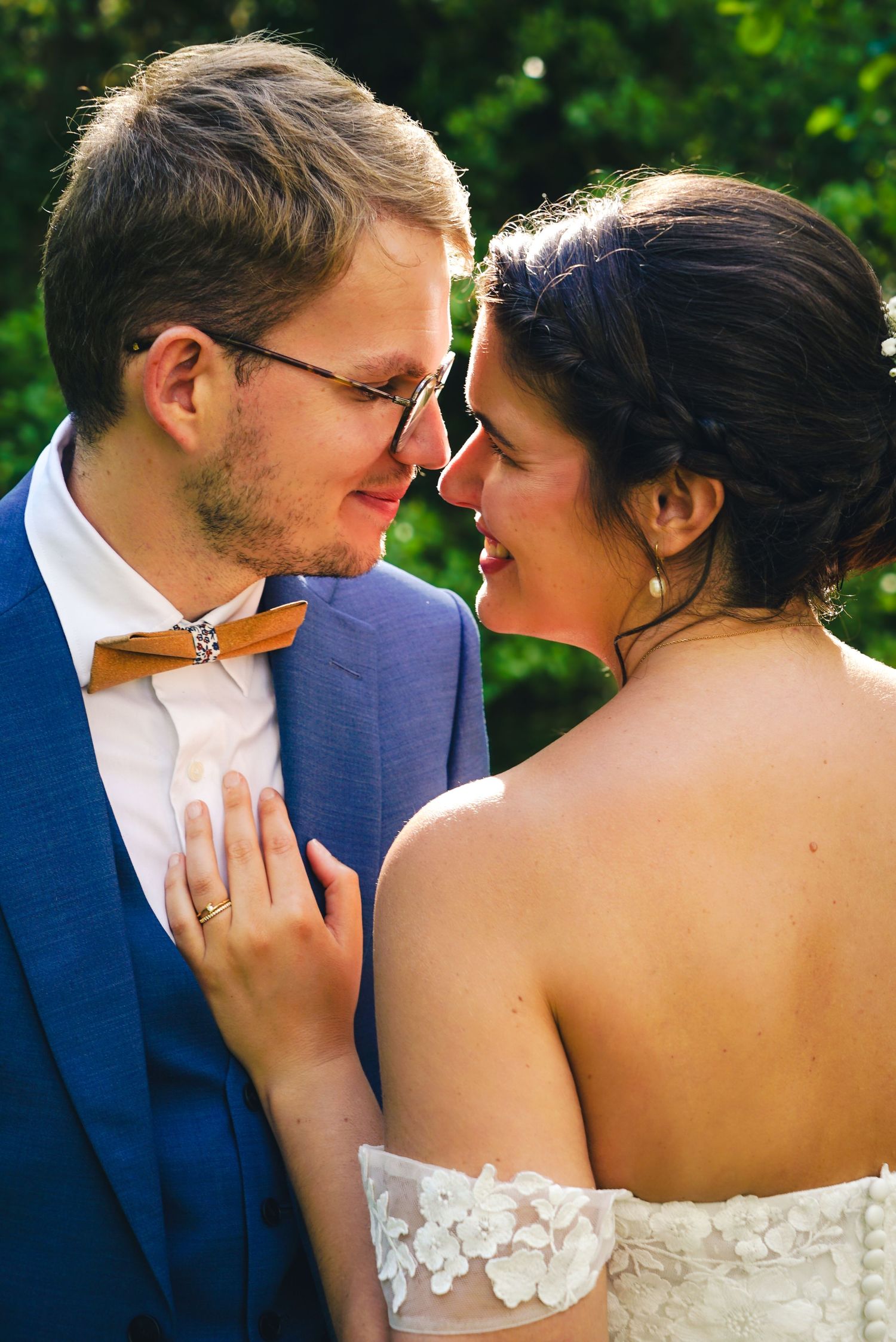 Intimate close-up of newlyweds sharing a tender moment in formal wedding attire.
