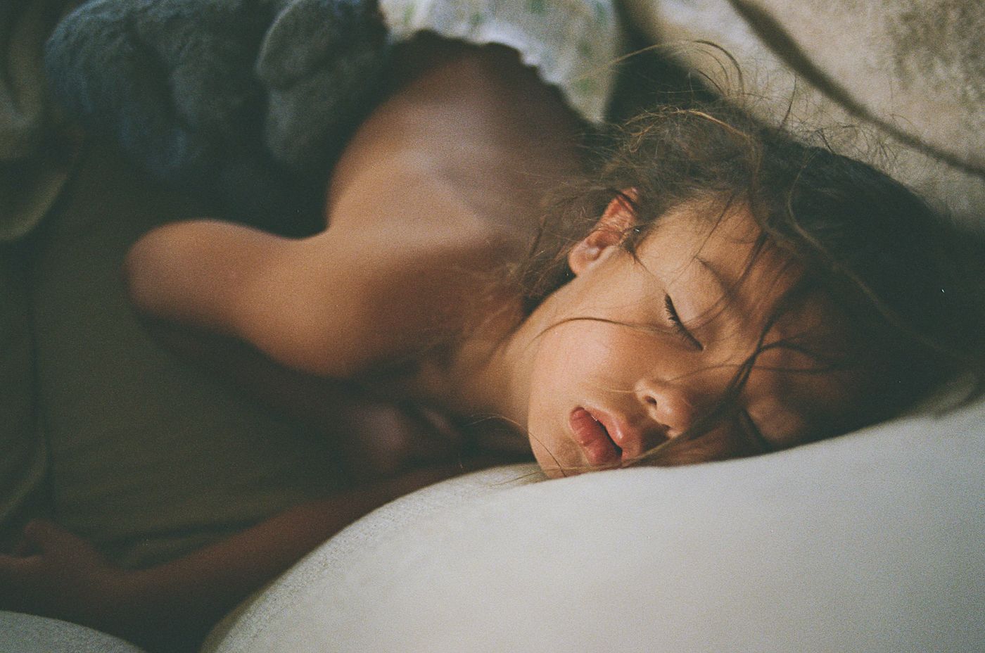 Moody low-light portrait series in dark tones showing atmospheric sleeping poses.