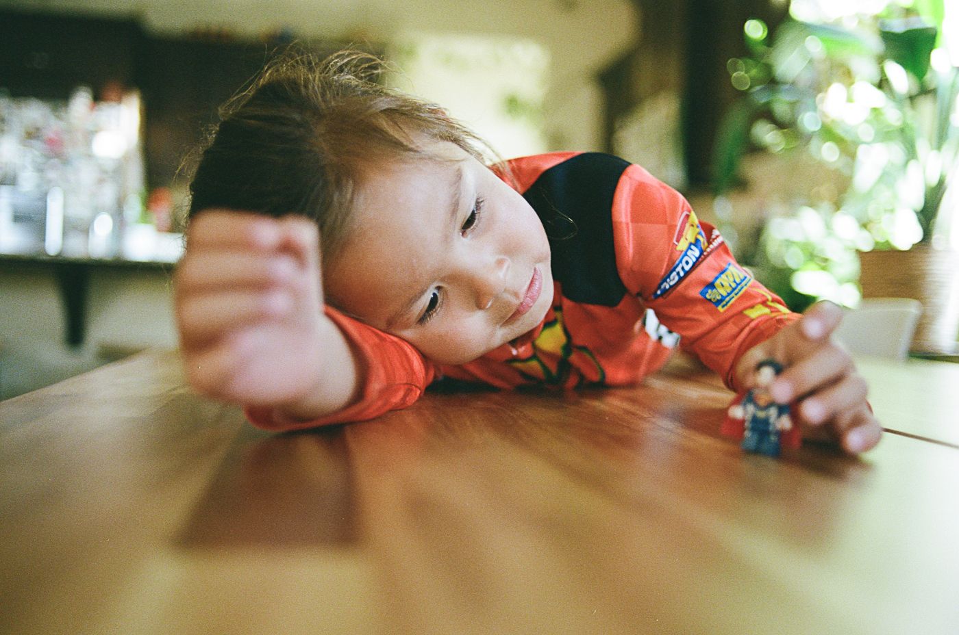 Hot Wheels toy cars being played with on a wooden surface in natural lighting.