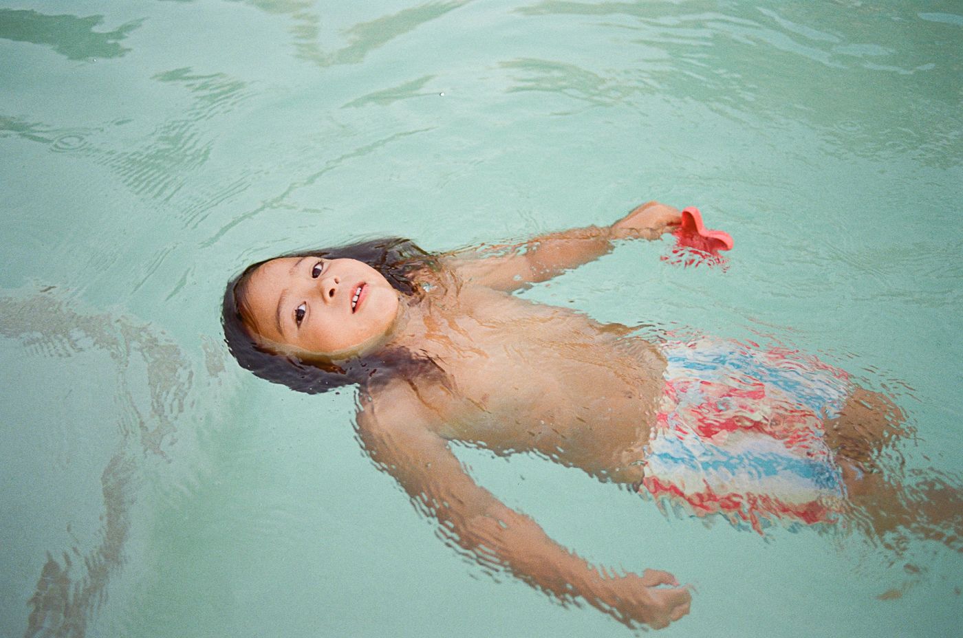 Peaceful floating in a serene blue swimming pool.