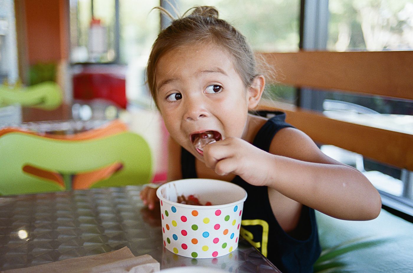 Enjoying ice cream in a polka dot cup on a sunny afternoon.