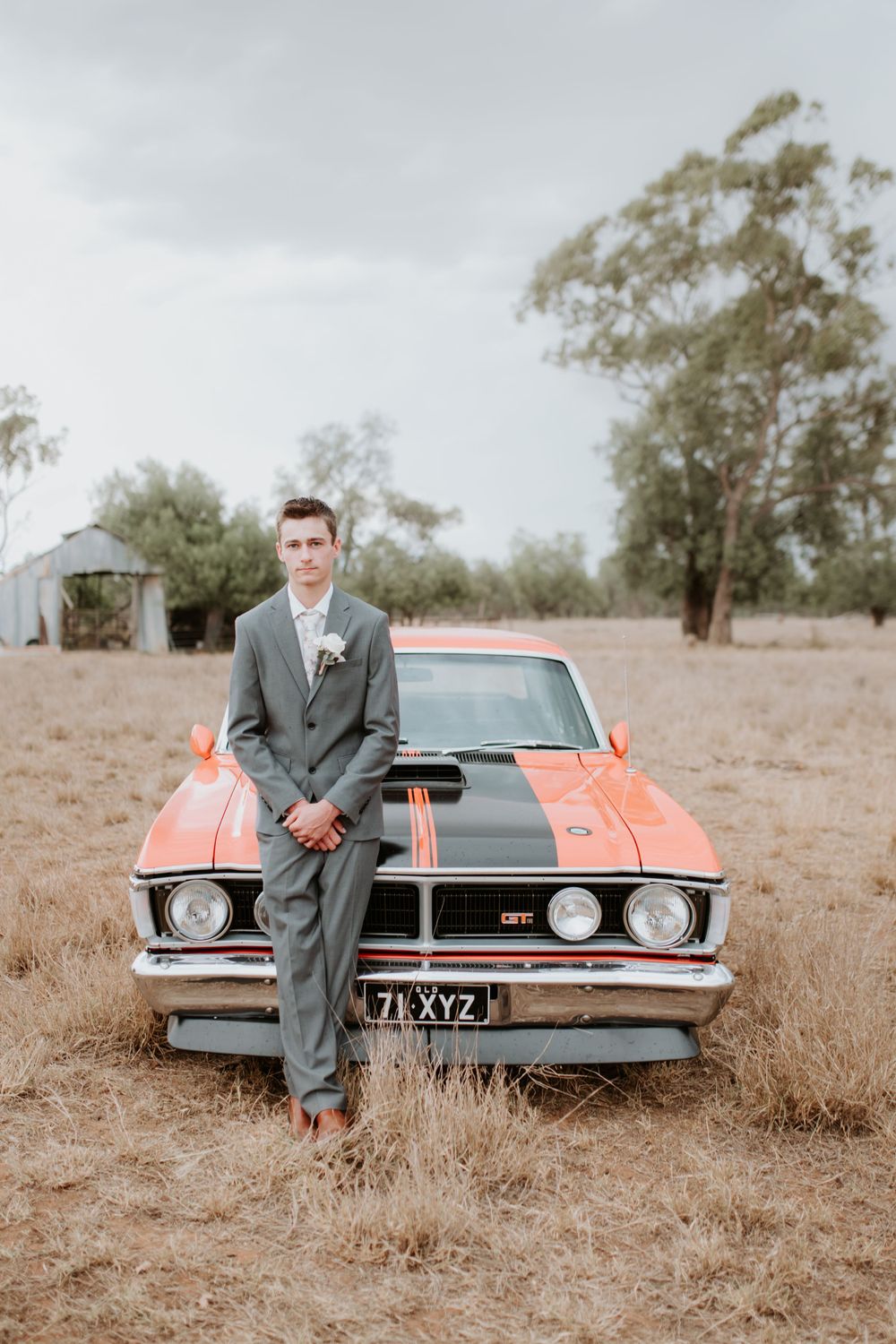Orange and black striped classic Ford GT parked in rural Australian landscape.
