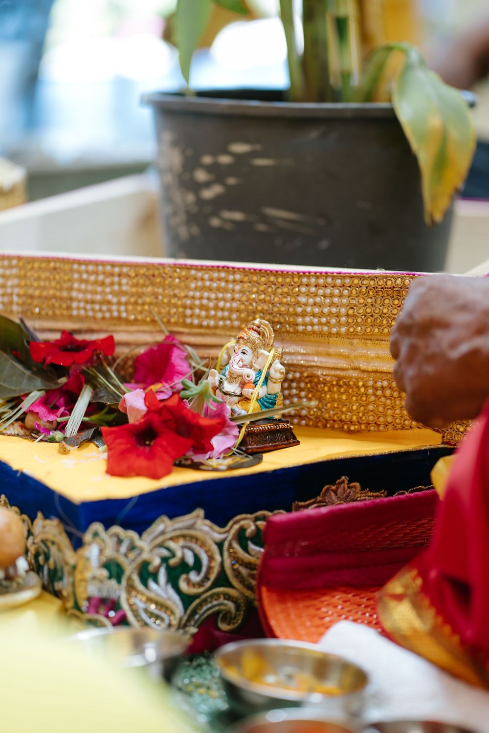 Decorative red flowers and ornate jewelry displayed on a textured surface with gold and blue accents.