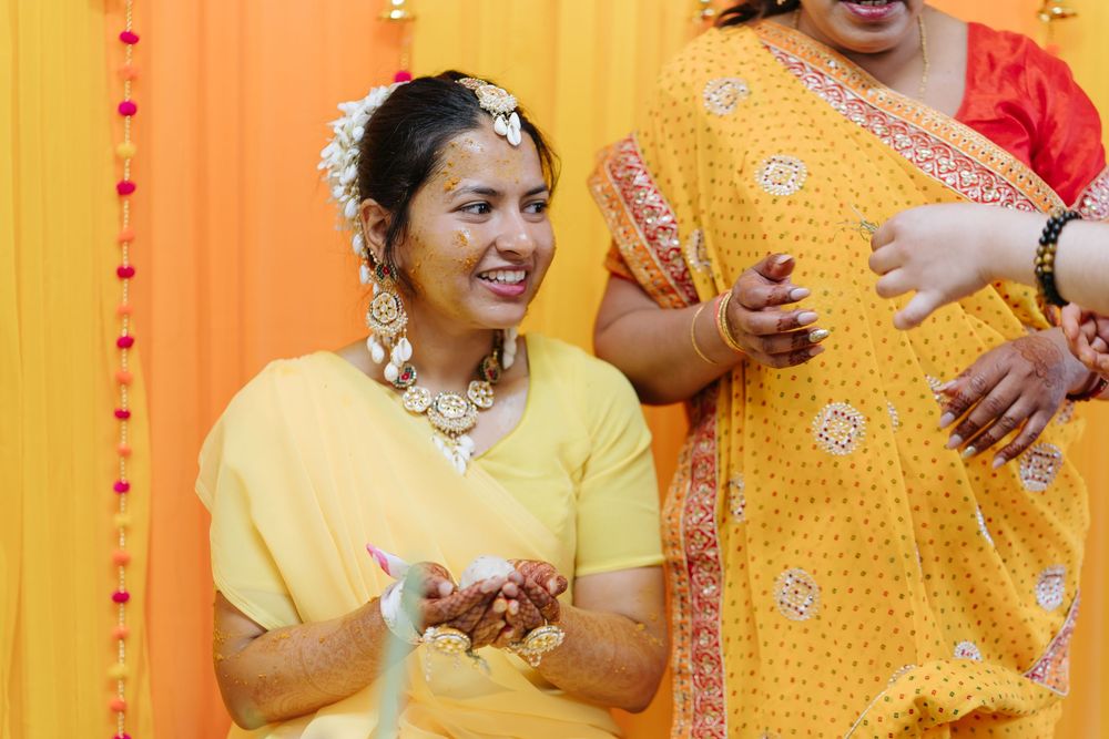 Group wearing traditional Indian attire in yellow and orange colors celebrating during a festive occasion.