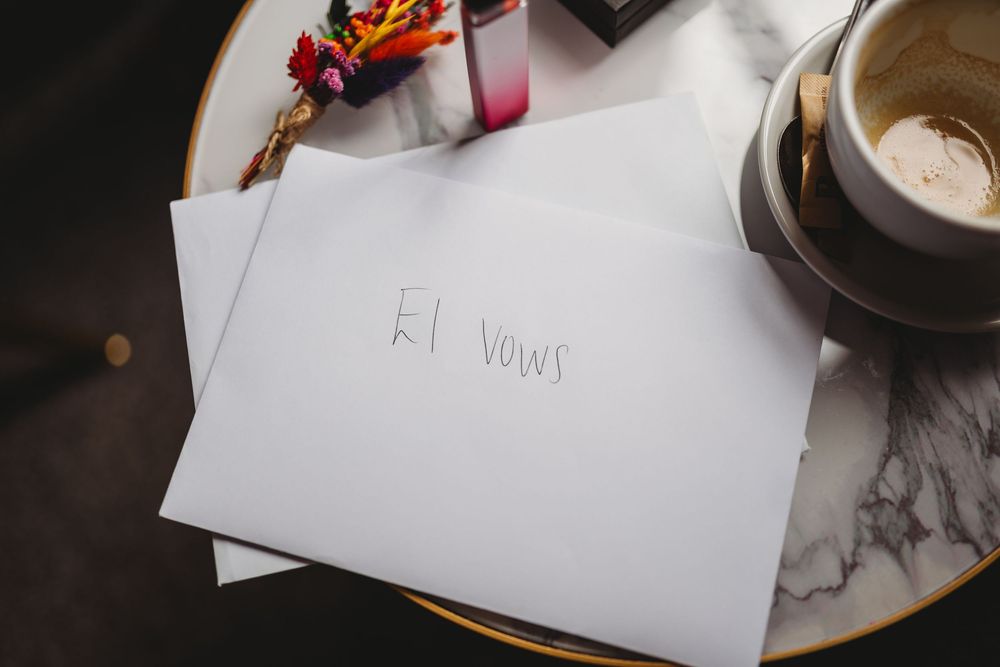 Handwritten note and coffee cup on marble surface with decorative elements.