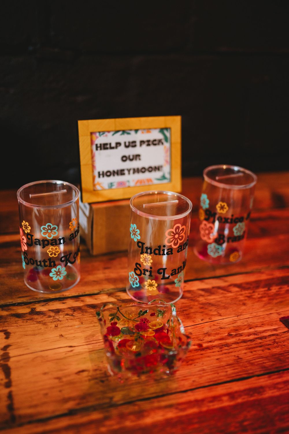 Decorative glass jars with floral designs arranged on a wooden surface.