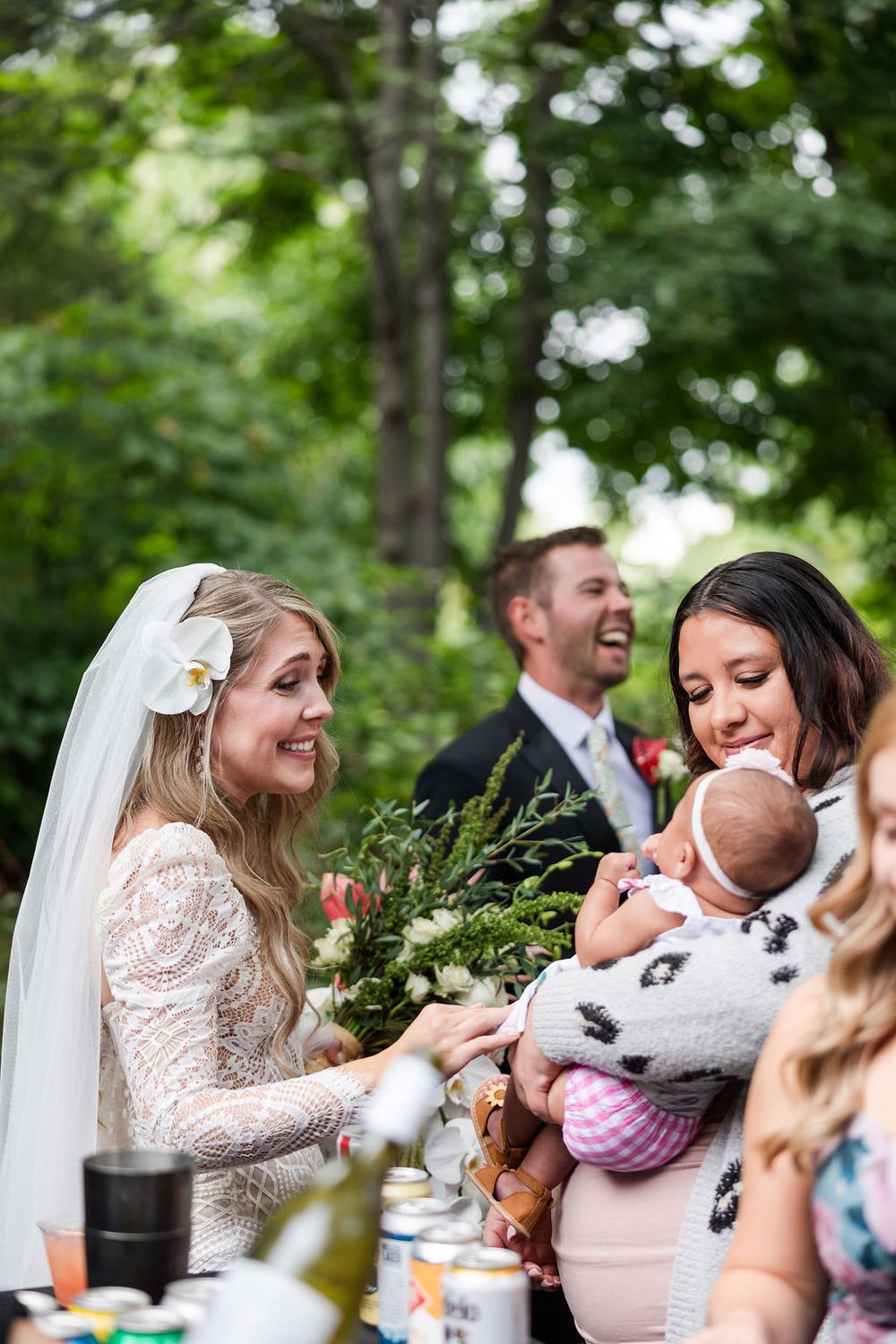 Candid moments from an outdoor wedding reception show joyful laughter and interactions between guests at a table.