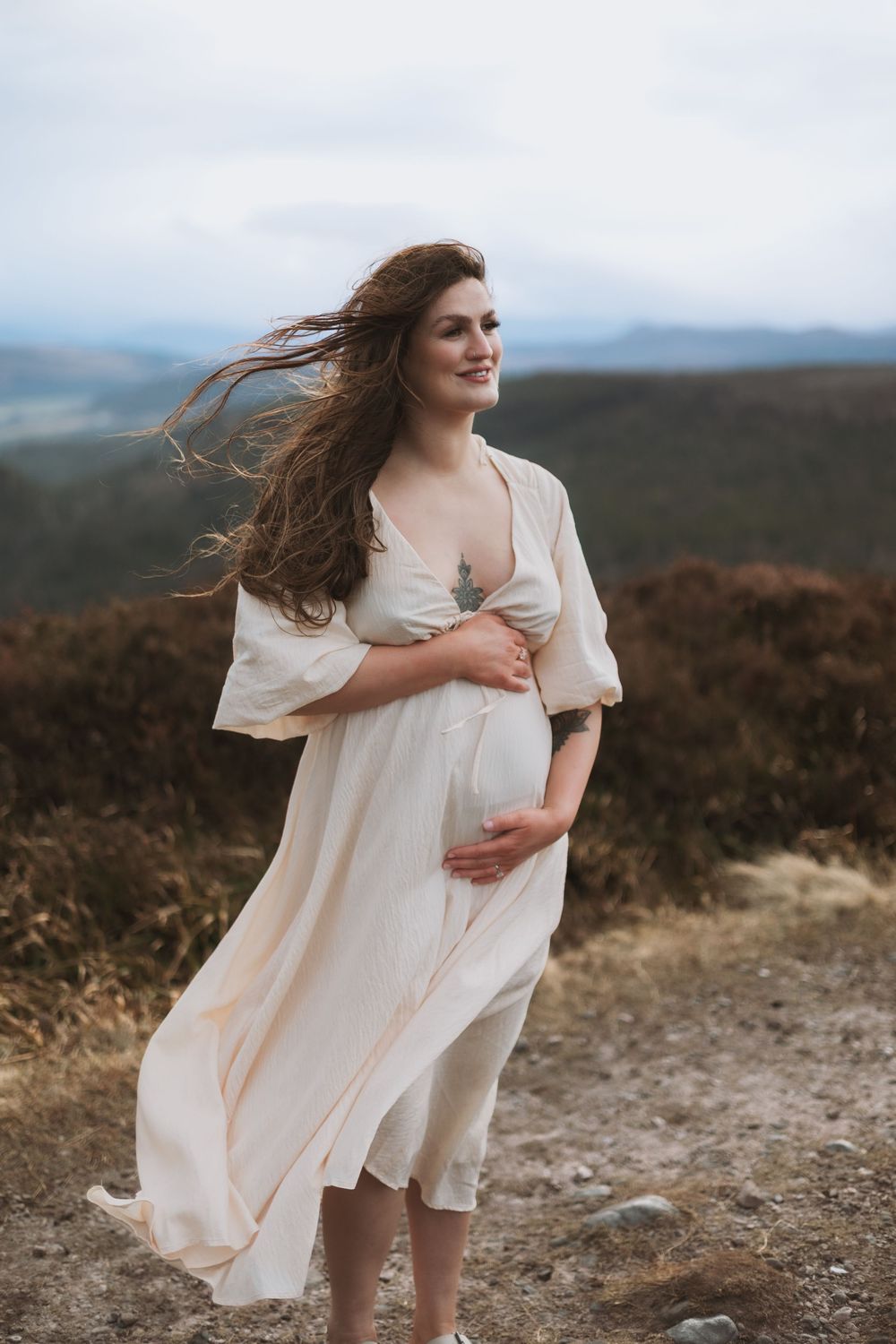 outdoor photo of pregnant woman wearing white flowy dress