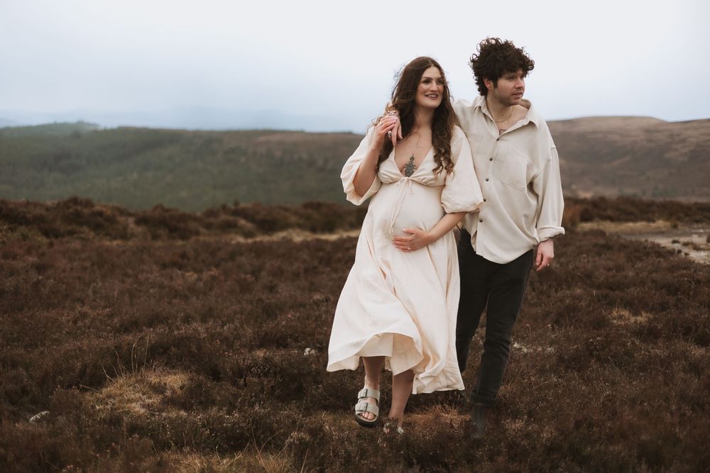 Outdoor maternity photography of couple on top of a mountain