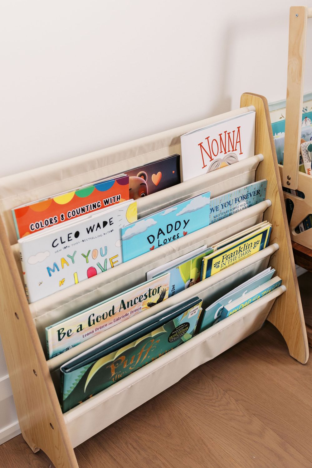 Close-up of childrens book display rack featuring titles including Be a Good Ancestor and Daddy Loves Me.