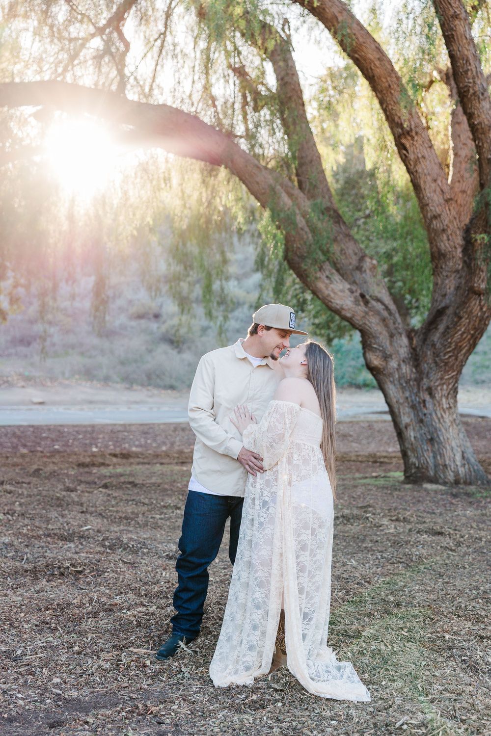 A romantic photoshoot sequence in a wooded area showing tender moments between a couple at sunset.
