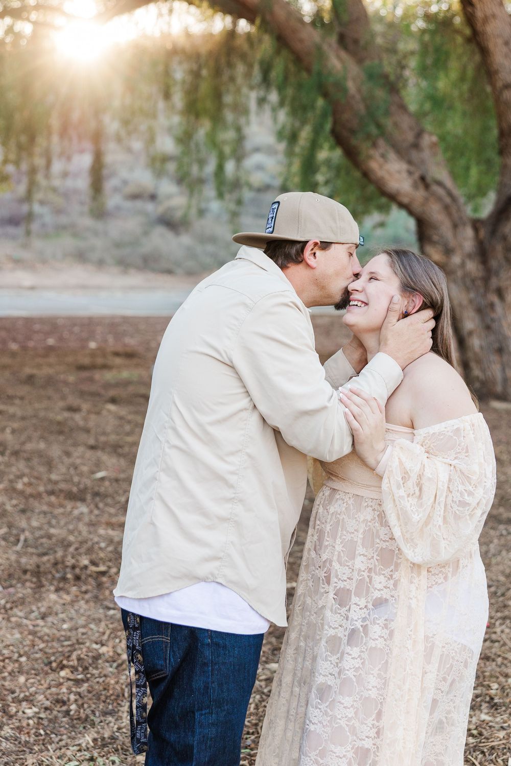 A romantic couple shares tender moments in a natural outdoor setting during a photo session.