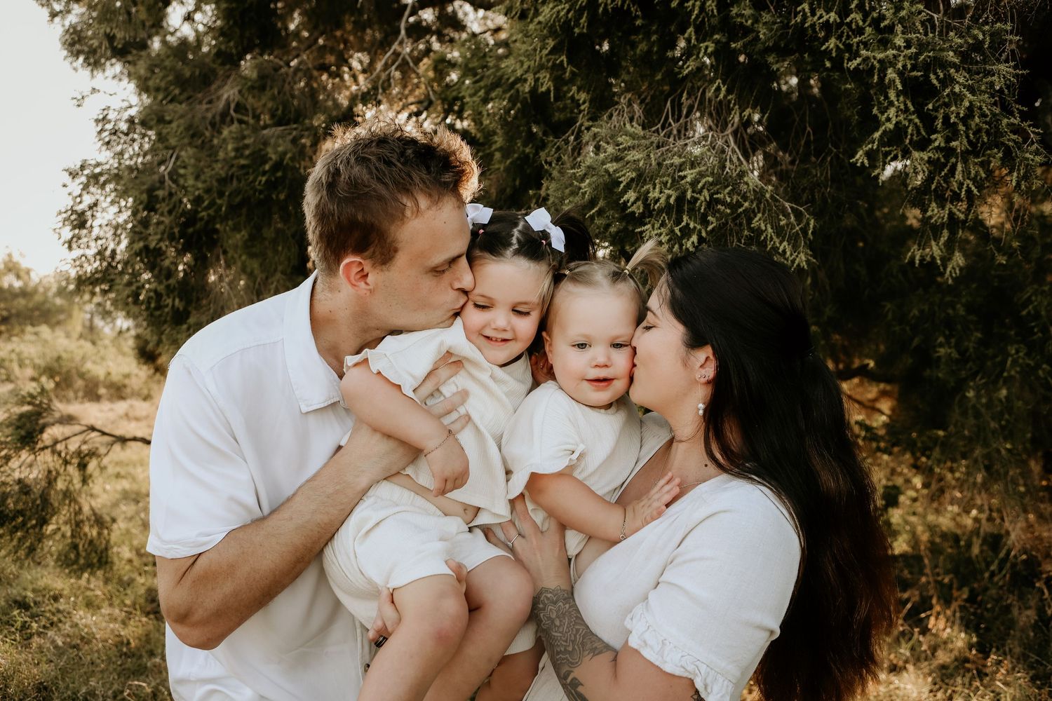 A family shares a tender moment together outdoors during a golden hour photoshoot in nature.