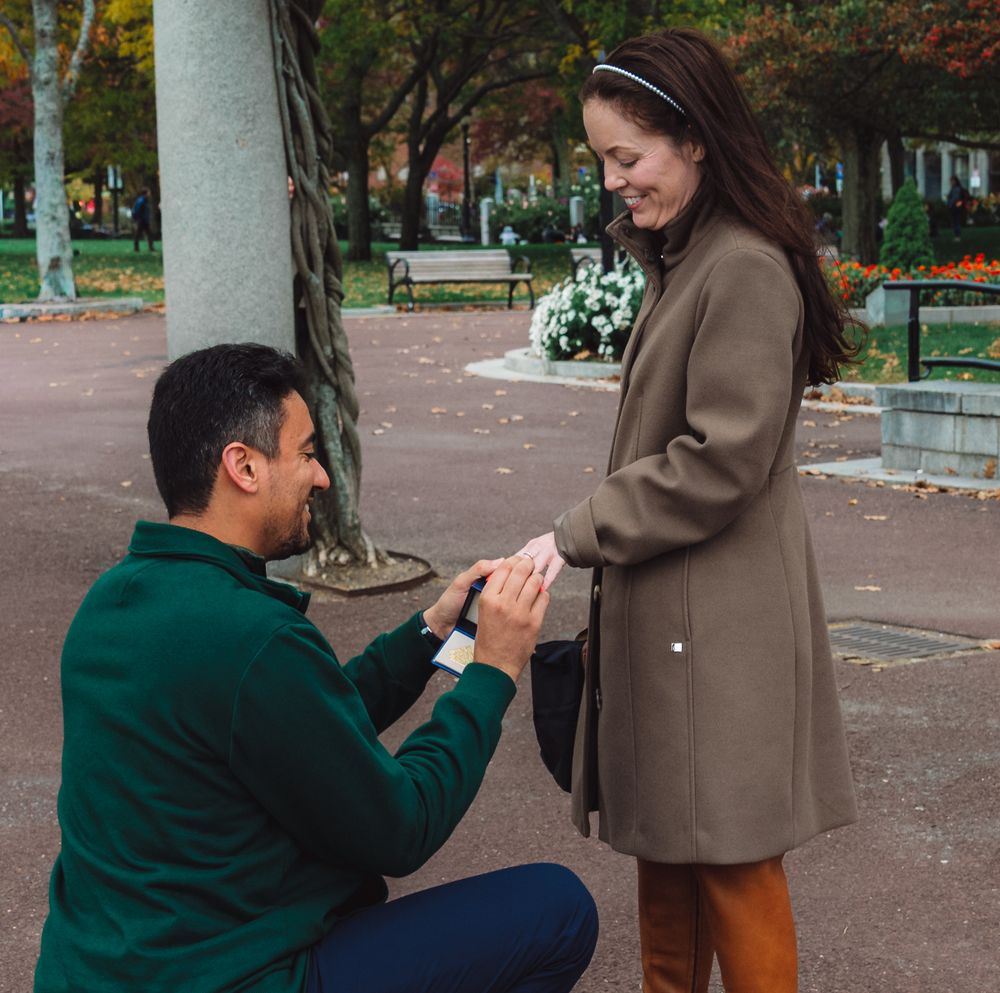 A heartfelt proposal scene in a park with autumn colors surrounding the couple.