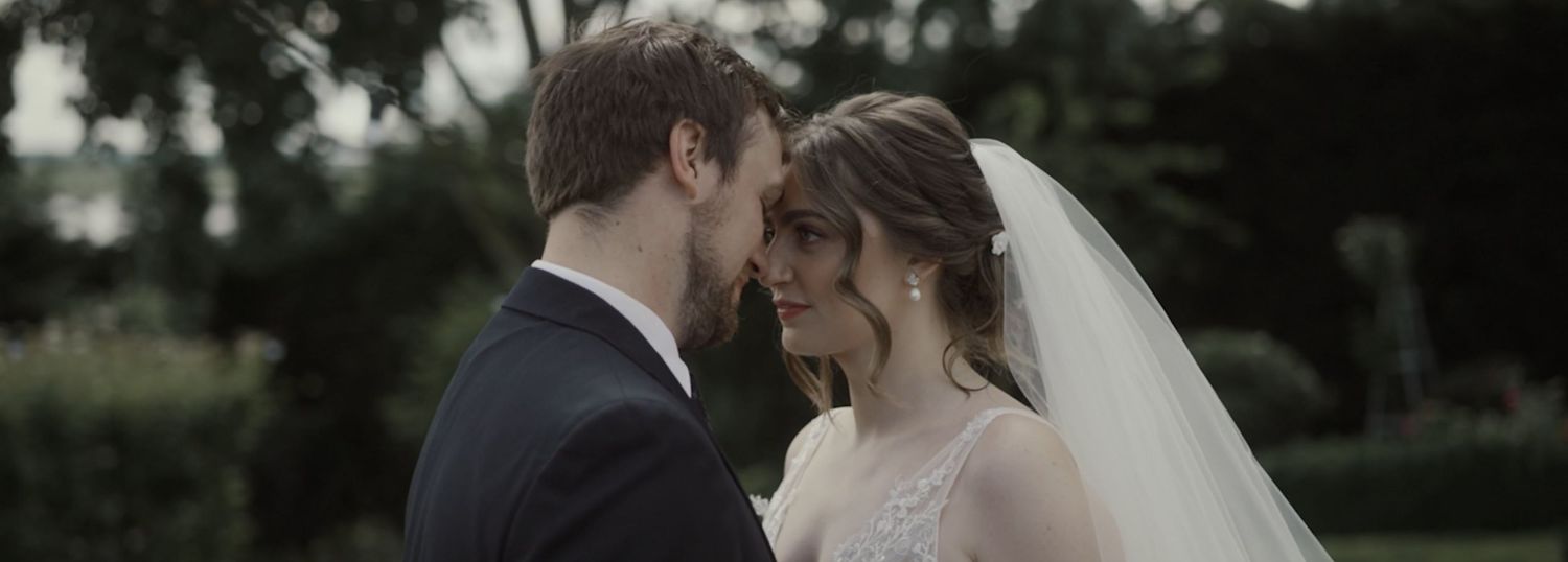 Newlywed couple embrace in front of historic domed building during wedding photo session.