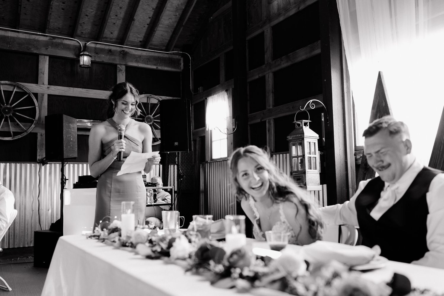 Black and white photo series showing a wedding celebration with guests and decorations in a rustic barn setting. Leavenworth, WA