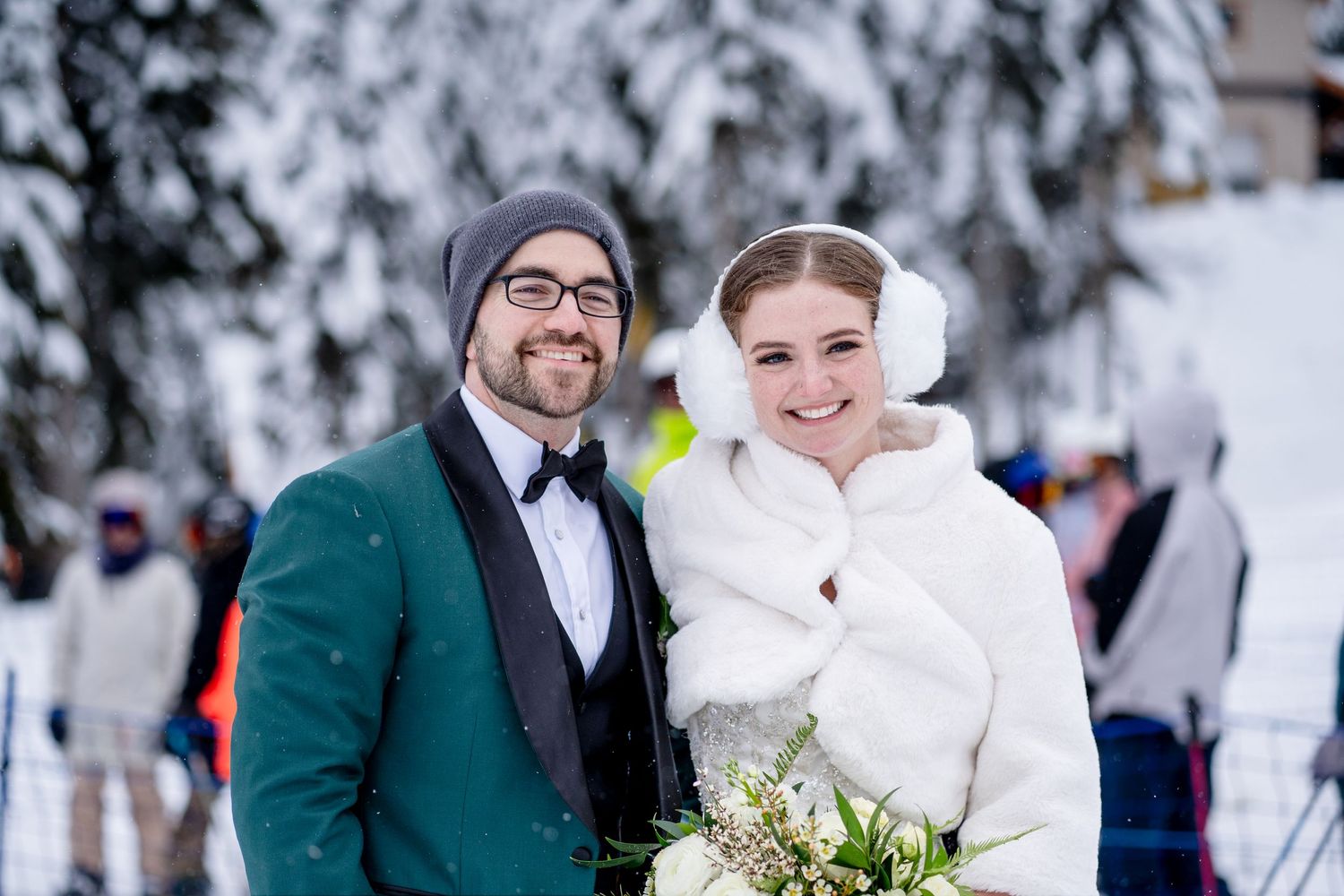 A winter wedding portrait with the couple wearing formal attire and white fur wrap against snowy backdrop.