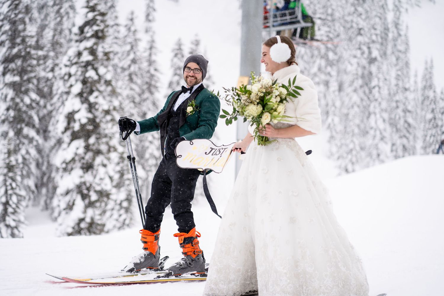 A winter wedding scene with a couple on skis surrounded by snow-covered trees.