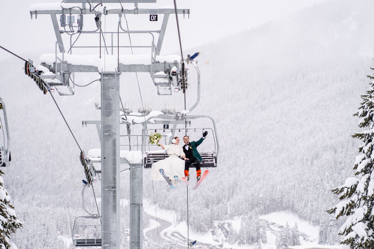 A ski lift rises through a snowy winter landscape with skiers riding up the mountain.