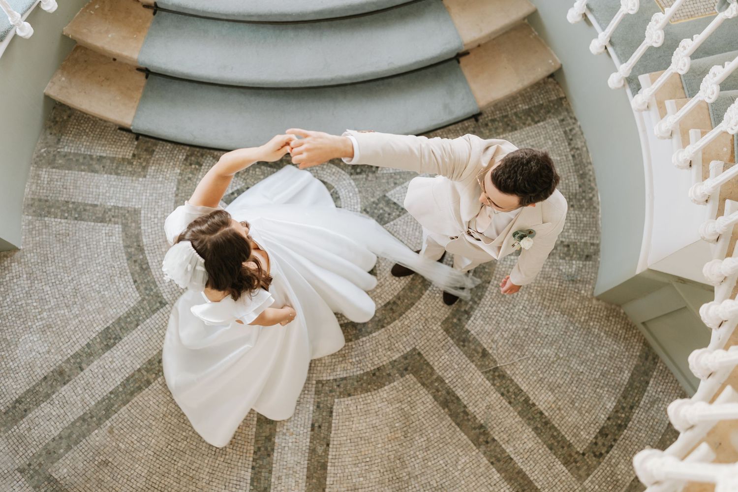 A bride in a flowing white dress twirls and spins gracefully on a textured concrete floor in a circular motion.