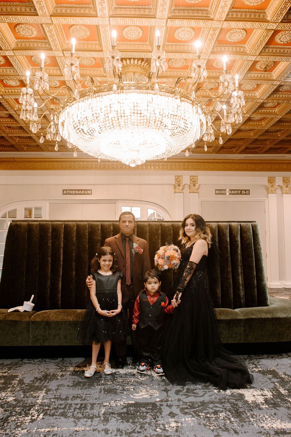 An elegant ballroom with ornate ceiling and crystal chandelier provides a luxurious backdrop for formal gathering.