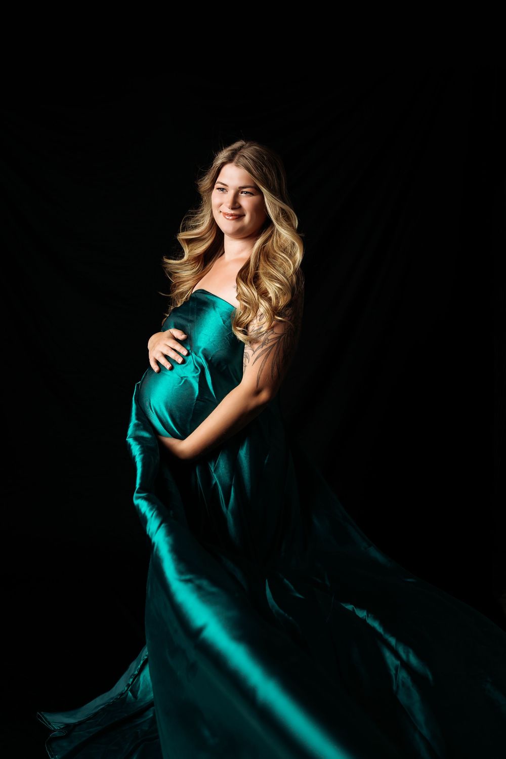 Flowing emerald green dress movement captured against dark background in dramatic lighting.